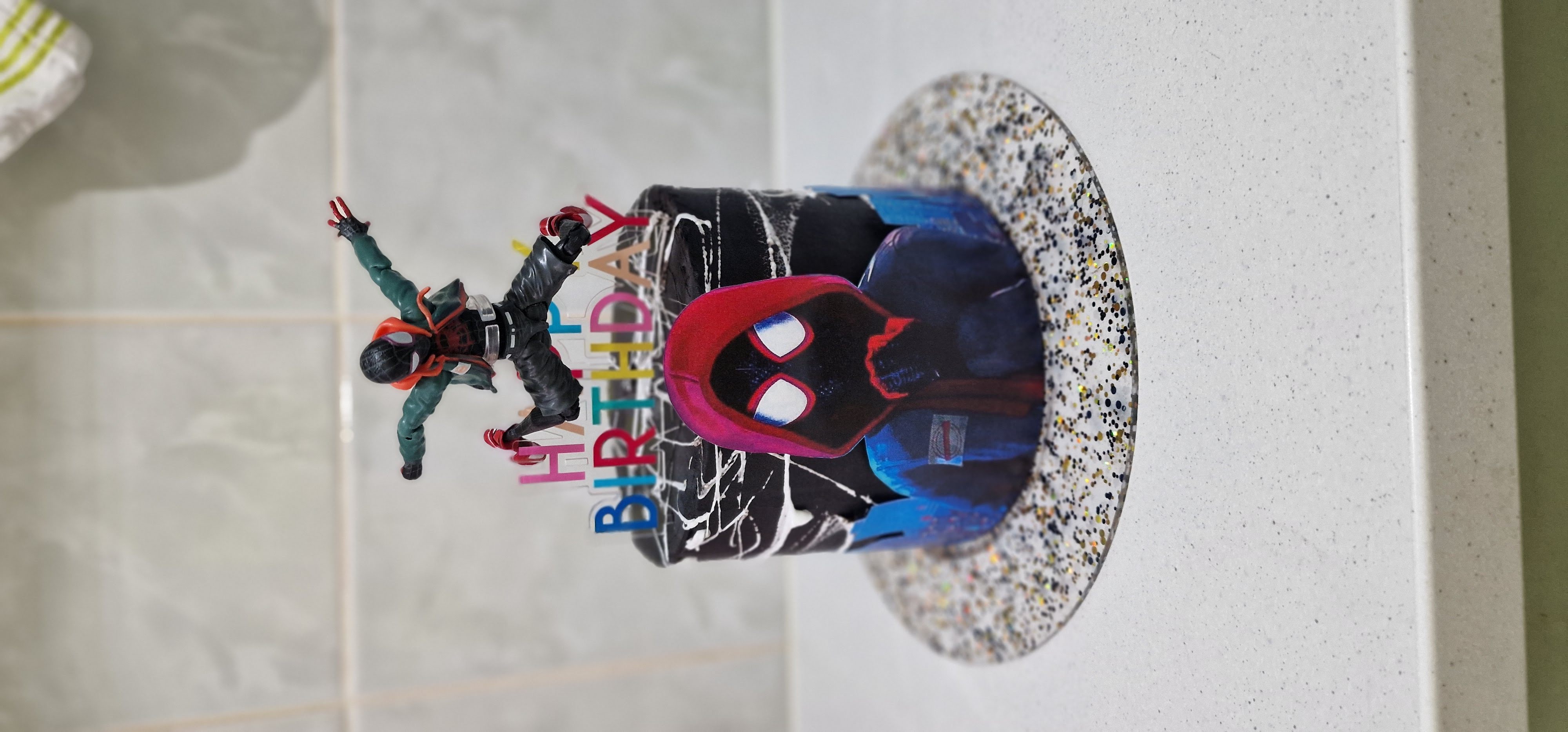 Bespoke tall black children birthday cake featuring a custom Spider-Man Miles Morales theme web design and topper figure by Fontaines Fancies