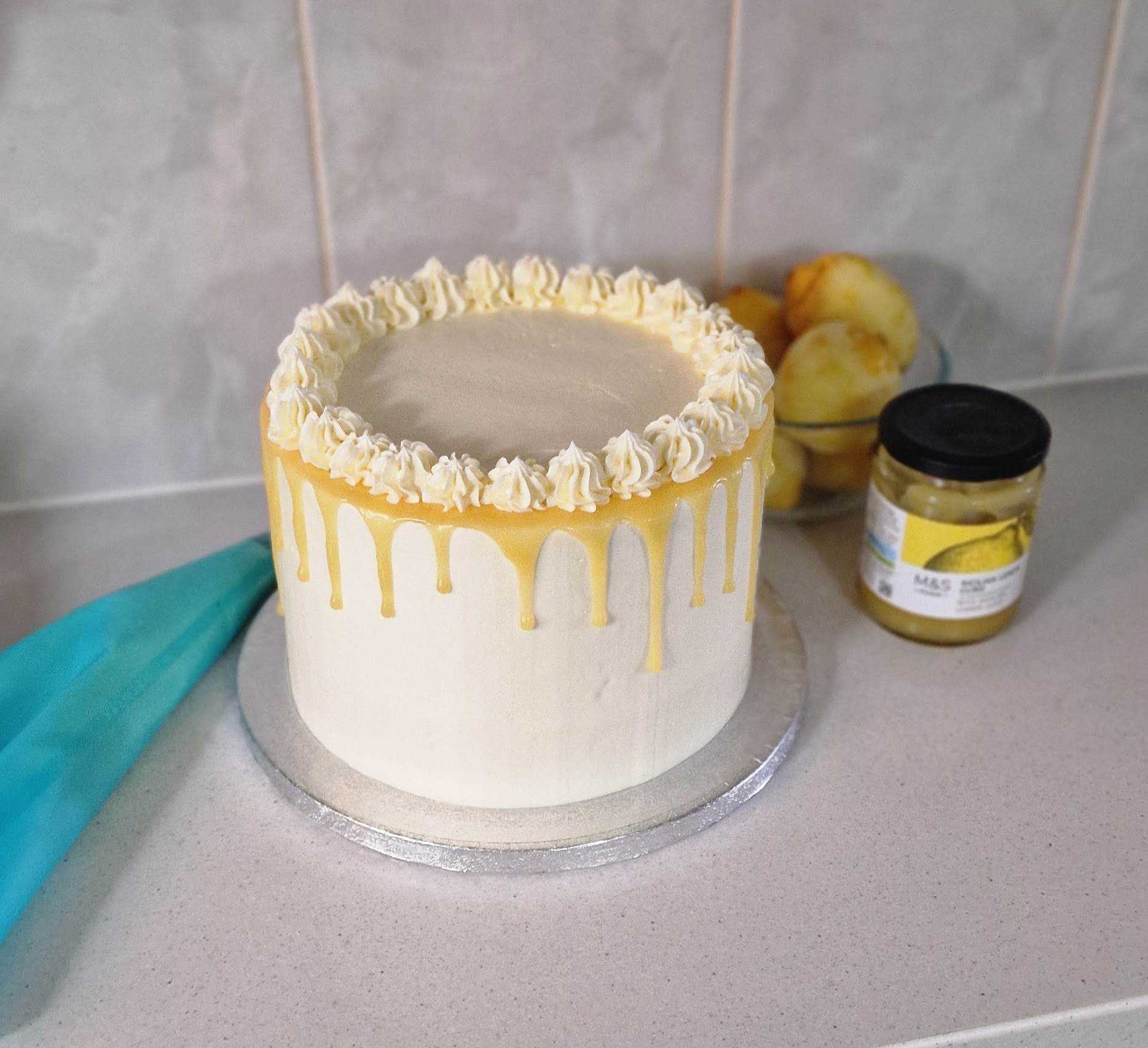 Bespoke lemon, white chocolate and lemon curd drip wedding cake setup by Fontaines Fancies